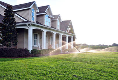 sprinklers in front of house watering the lawn